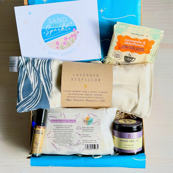 Wellbeing Gift Set with Devon and Cornish products including organic lavender eye pillow, bath bombs, hand cream, sleep oil and herbal tea in Sand and Sparkle Gift Box